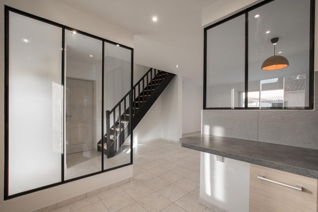 Escalier type industriel réalisé en bois avec deux limons latéraux, ballustres verticales et main courante bois laqué
